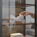 Weißes Raysin Deko‑Motorrad dekorativ auf Regal platziert, minimalistisches Wohnambiente.